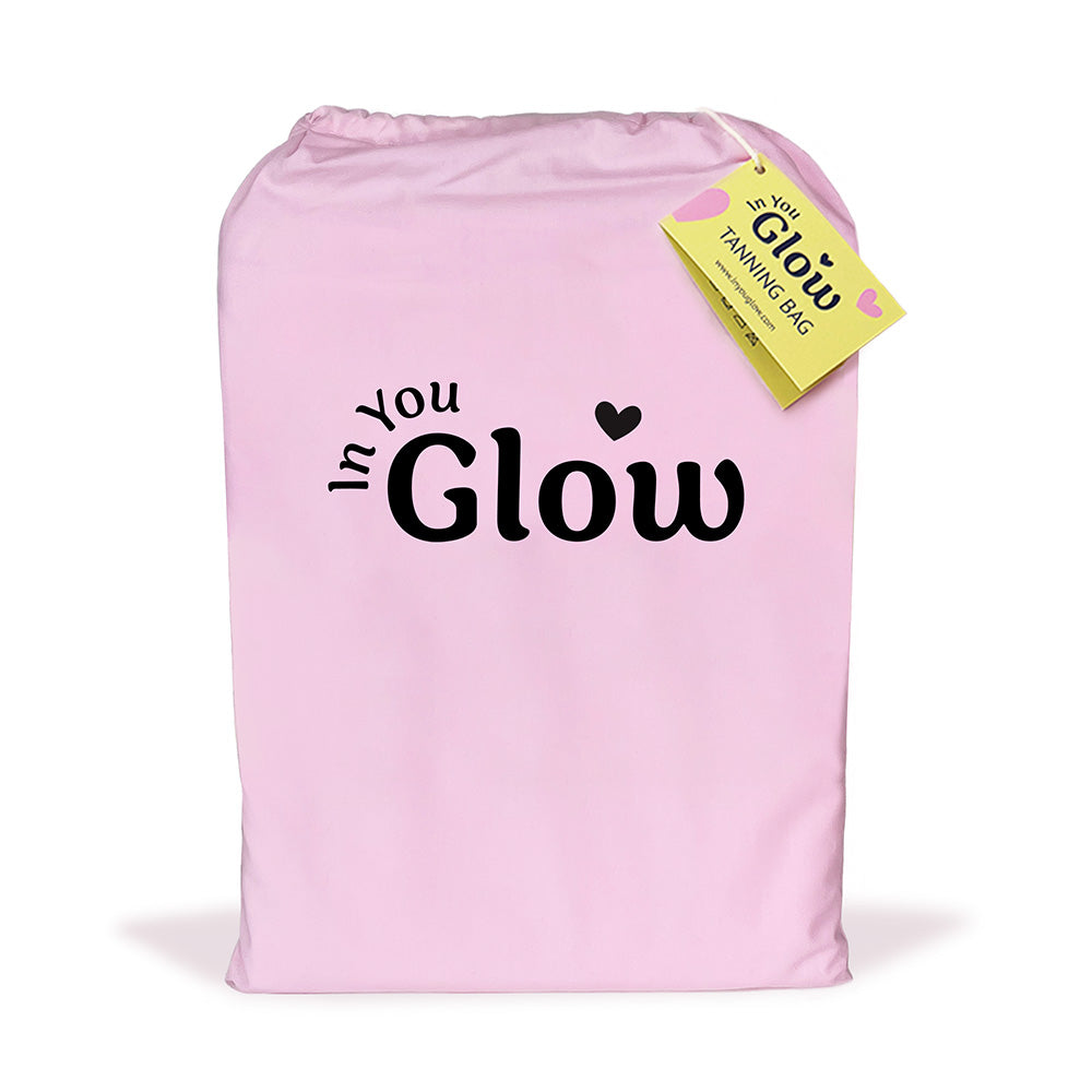 Pink self tanning bag with 'In You Glow' text and a yellow tag on a white background
